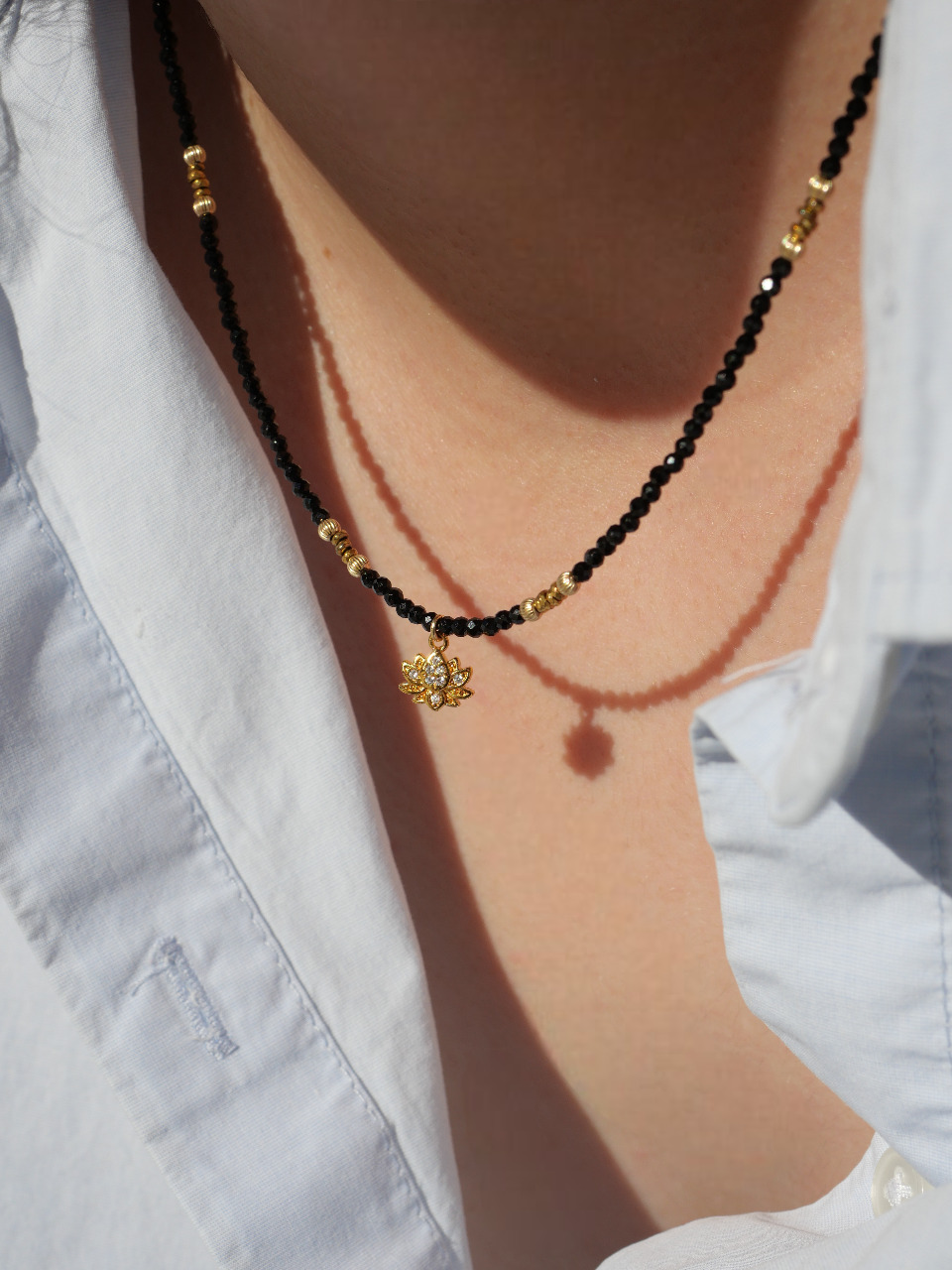 collier en pierres naturelles noires et pendentif plaqué or